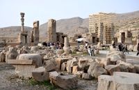 عکسی از یک زن در حال شست‌وشوی ظروف در تخت جمشید
